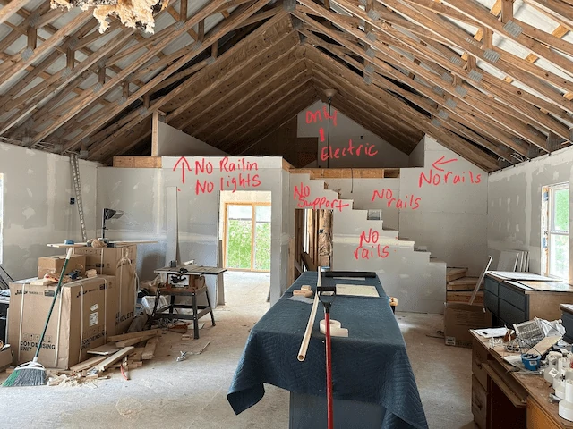 Unfinished ceiling, loft, stairs, living room, and kitchen.
